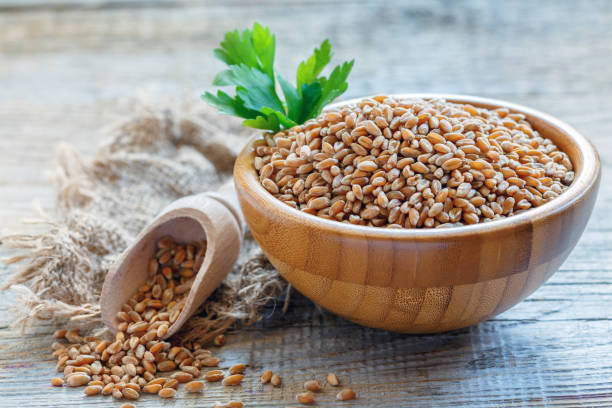 istock Uncooked whole grain wheat in a wooden bowl. 868576946