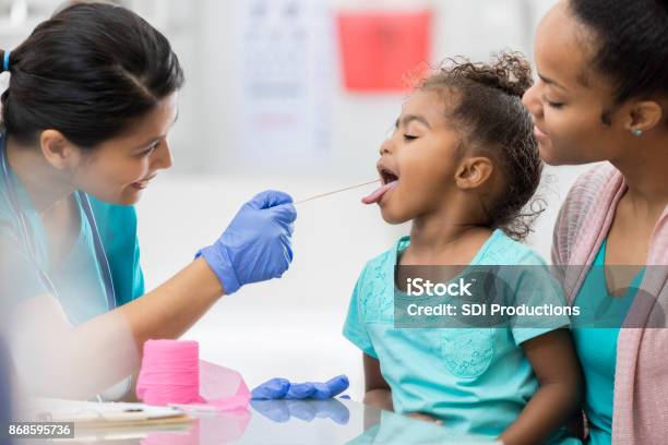 Brave Little Girl Opens Wide For Throat Swab At Doctor Stock Photo - Download Image Now