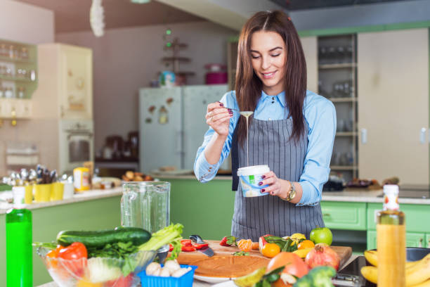 istock Cheerful young female chef cooking dessert adding condensed milk in dish in her kitchen 868601272