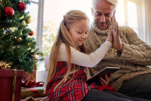 istock Little girl with grandfather using digital tablet at home 868602662