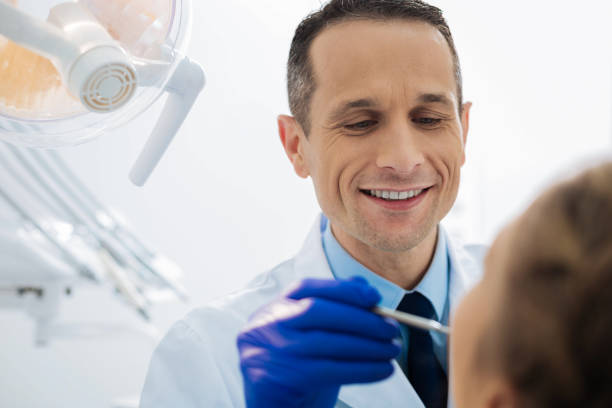 istock Positive male dentist working with a patient 868611006