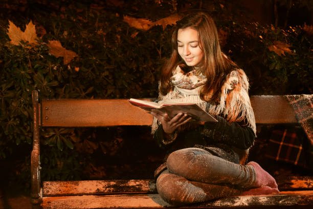 istock Caucasian girl reading a book on the banch 868611048