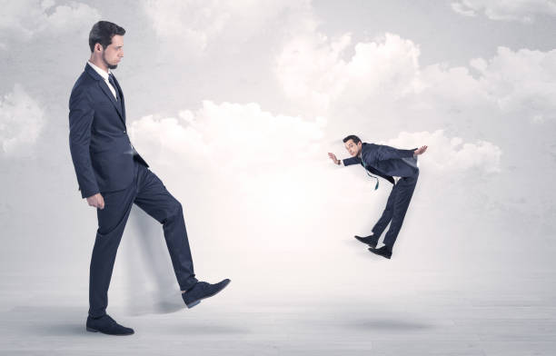 istock Big boss kicking little employee 868611480