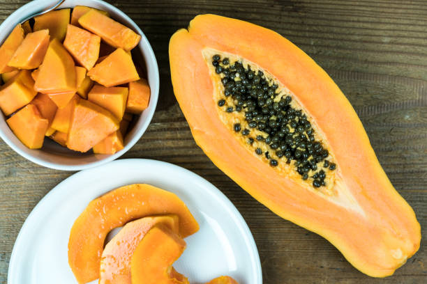 istock Papaya cut in pieces on wooden table 868612036