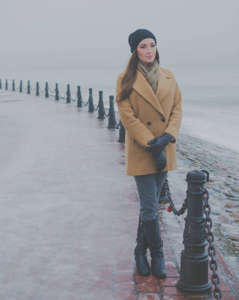 istock beautiful girl in winter on the waterfront 868614972