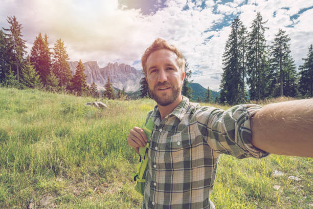 Young man taking a selfie portrait in the Dolomites in Alto Adige region, Italy.