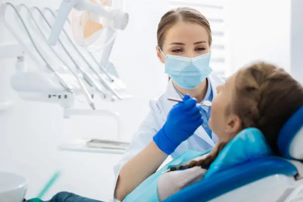Photo of Positive female dentist being at work