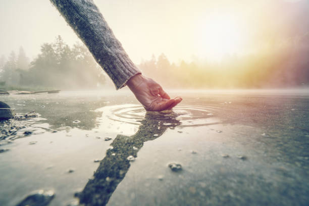 human hand cupped to catch fresh water from mountain lake, switzerland - mountain drop europe switzerland imagens e fotografias de stock