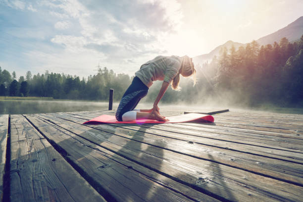 istock Girl in Camel pose, yoga training by the lake 868622868