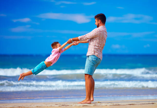 istock happy excited father and son playing on summer beach, enjoy life 868632814