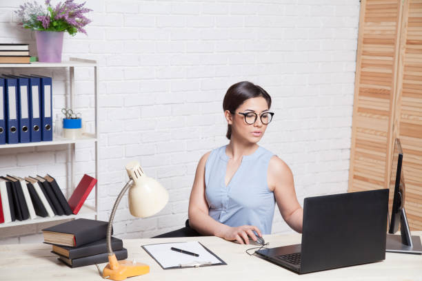 istock business girl sits in an Office behind a desk with a computer 868638912