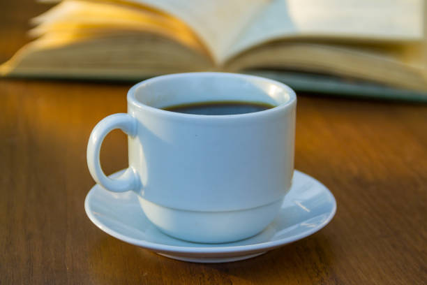 istock Cup of coffee and book on wooden table 868647838