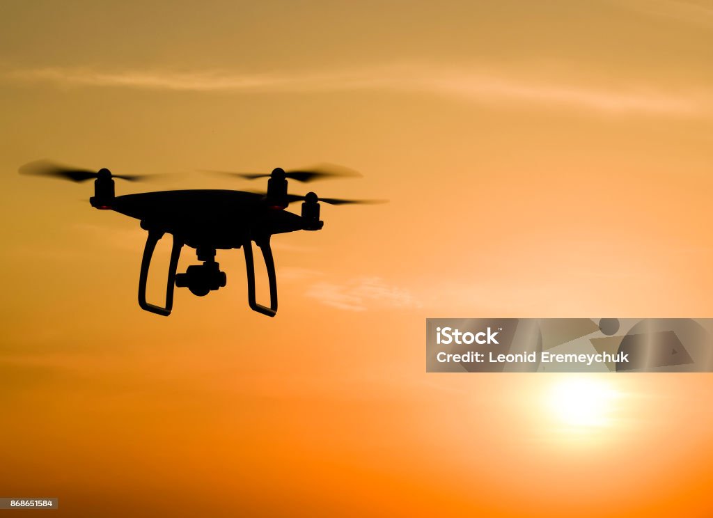 Un cuadricóptero silueta contra el fondo de la puesta del sol - Foto de stock de Dron libre de derechos