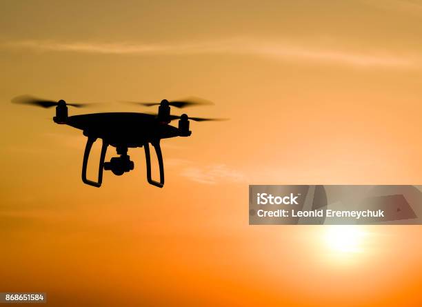 Un Cuadricóptero Silueta Contra El Fondo De La Puesta Del Sol Foto de stock y más banco de imágenes de Dron