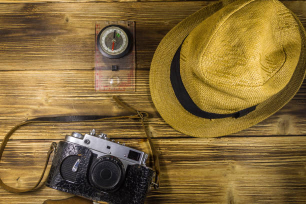 istock Compass, hat and retro photo camera on wooden background 868658364
