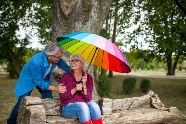istock The old couple in the rain with umbrellas 868659432