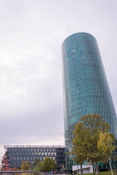 istock The Westhafen tower at the river Main in Frankfurt with a tree in front on a cloudy day 868659522