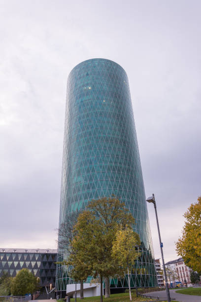 istock The Westhafen tower at the river Main in Frankfurt with a tree in front on a cloudy day 868659590