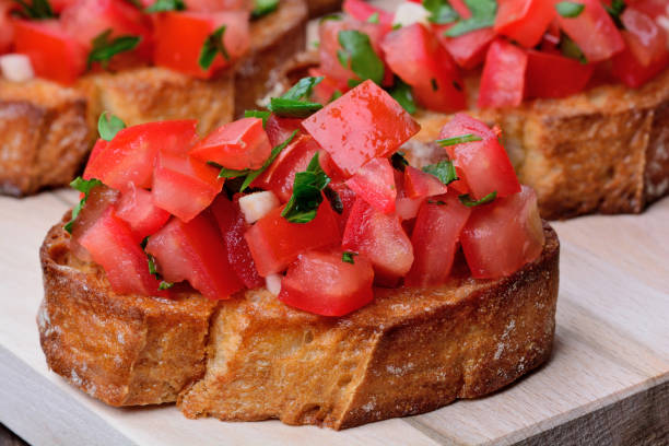 istock Bruschetta with tomatoes and garlic on chopping wooden board 868659696