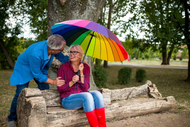 istock The old couple in the rain with umbrellas 868662808