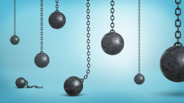 istock 3d rendering of a many black iron wrecking balls hanging on chains and fallen down on blue background 868665508