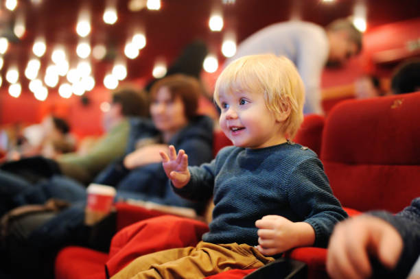Cute toddler boy watching cartoon movie in the cinema stock photo