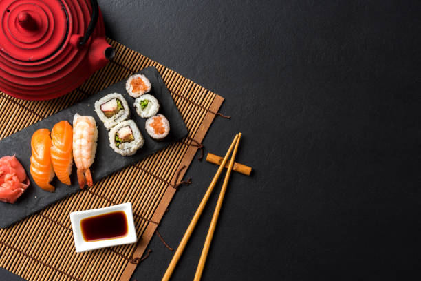ensemble de sushi avec wasabi, sauce soja et théière sur fond noir de pierre - sushi styles photos et images de collection