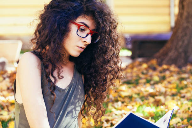 istock Student girl reading a book in the park 868676776