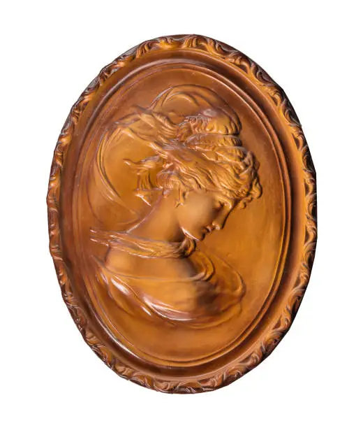 Photo of bronze woman's face in a medallion on a white background