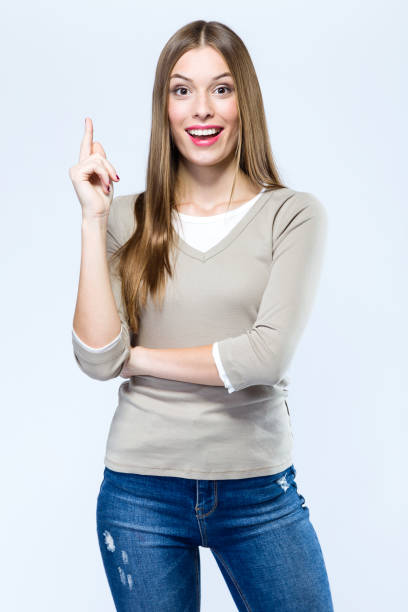 istock Beautiful young woman pointing up over white background. 868684236