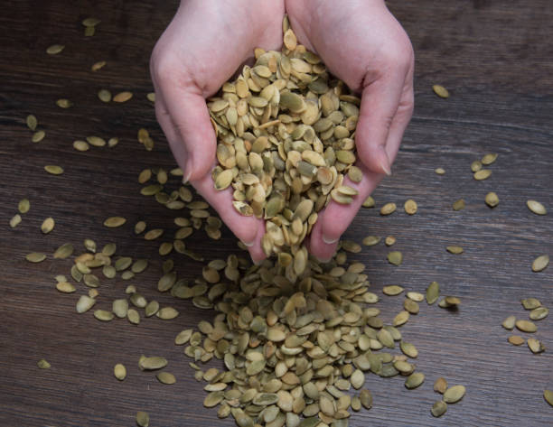 istock Pumpkin seeds pour out on the table 868688166