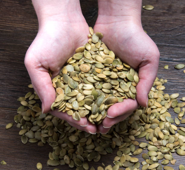 istock Female hands hold pumpkin seeds 868688314