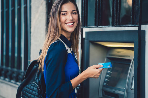 Woman withdrawing money at the ATM Smiling woman at the ATM ready to withdraw cash money   ++++ Note for the inspector: Credit card is fake ++++ bank account photos stock pictures, royalty-free photos & images
