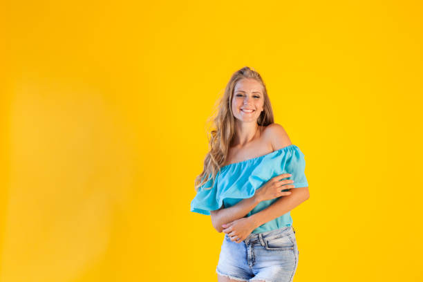 beautiful blonde with blue shorts on a yellow background