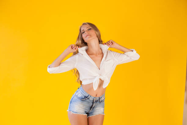 beautiful blonde with blue shorts on a yellow background