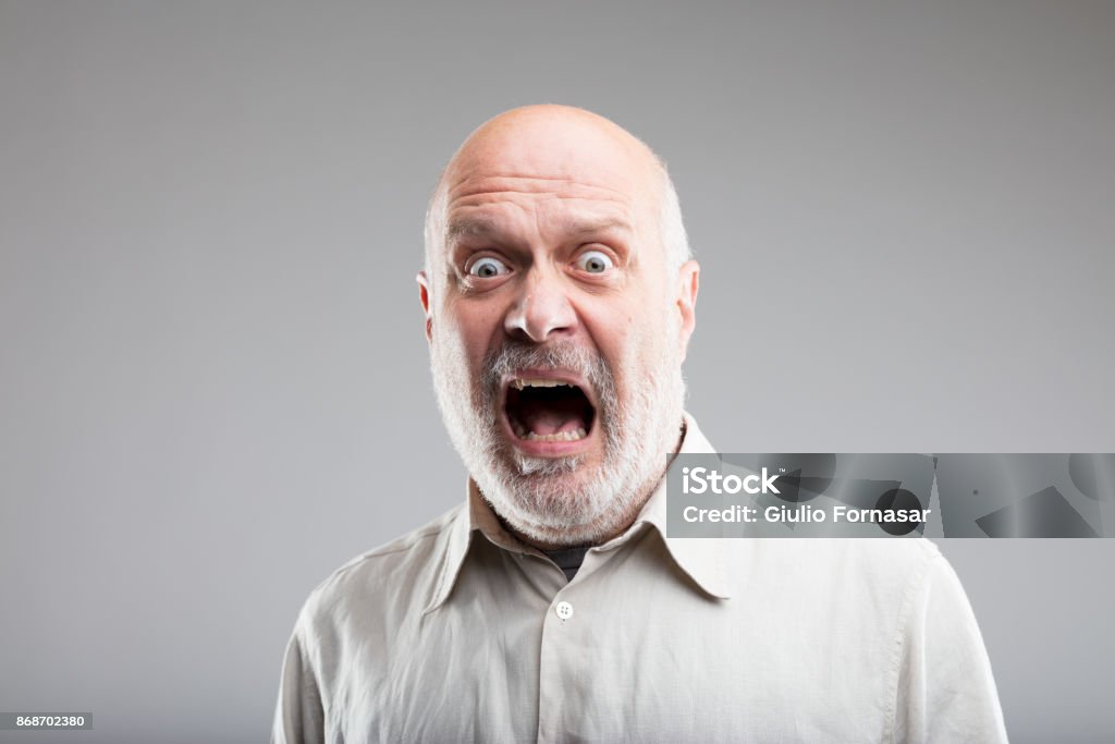 strong exaggerated fear expression of an old man fear on the face of an old scared man - concept of elemental FEAR Fear Stock Photo