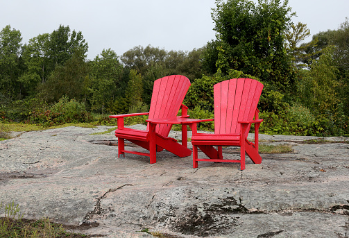 Two red  chairs on a granite hill in a park