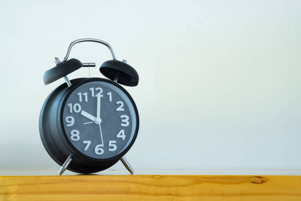 istock Black color vintage alarm clock on table with copy space, wake up time concept 868703330