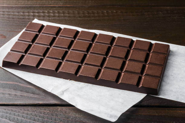 istock Bitter, dark chocolate bar on wooden planks background 868704176
