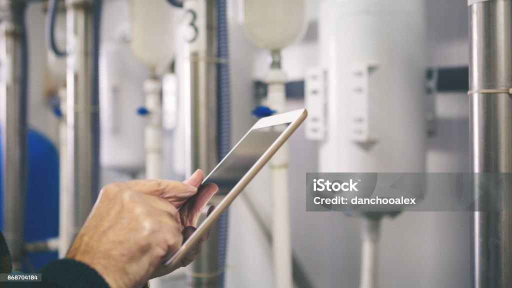 Senior repairman in boiler room checking pipes Senior man in a boiler room working. Shallow DOF. Developed from RAW; retouched with special care and attention; Small amount of grain added for best final impression. 16 bit Adobe RGB color profile. Radiator - Heater Stock Photo