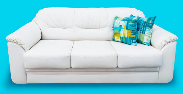 istock White eco leather sofa with blue pillow. Soft snow white couch with coach-type screed capitone. Classic divan on isolated background 868710666