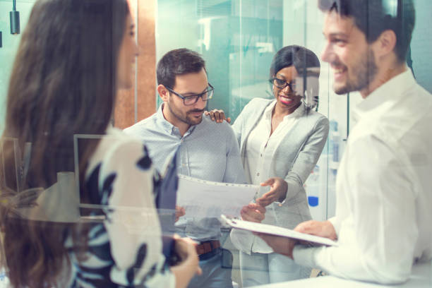 istock Through glass view of business people working with documents in office. 868713588
