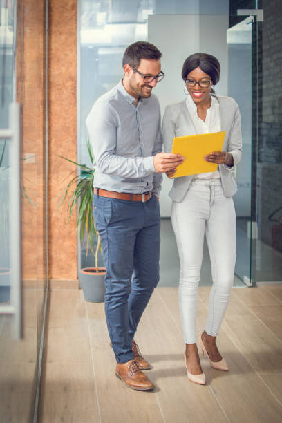 istock Business people walking through office lobby and discussing document. 868713870