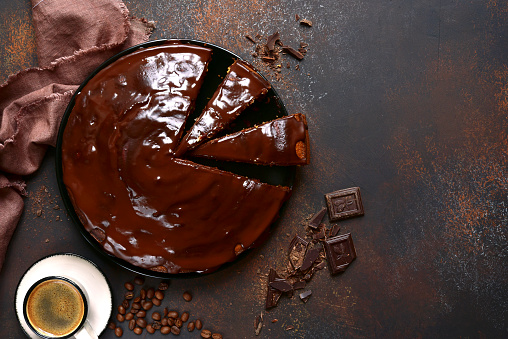 Chocolate sponge cake over dark brown slate,stone or metal background.Top view with copy space.