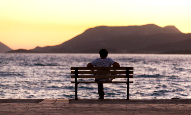 istock Lonely Man Sitting Watching the Sunset 868717024