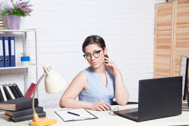 istock business girl sits in a white Office works at the computer 868717686