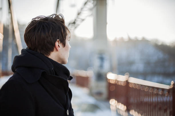 Young man standing on the bridge stock photo