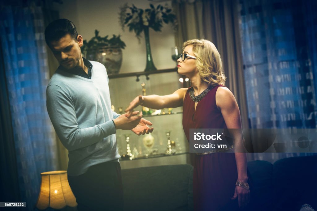 Wife slapping husband Side view of a blonde haired woman slapping her husband. Hitting Stock Photo