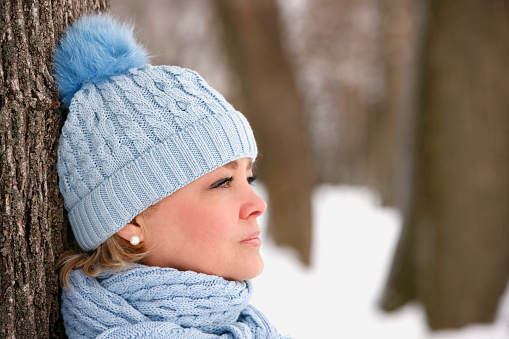 Portrait of attractive mature woman outdoors in winter wearing tuque and scarf.