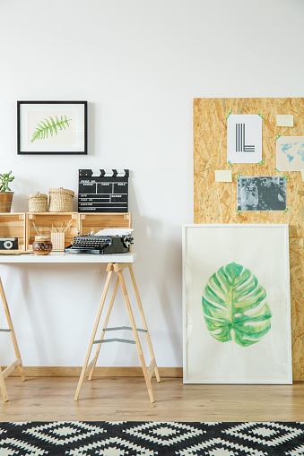 Artist's workspace with simple wooden furniture and paintings